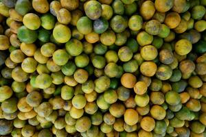 Piles of oranges being sold in a traditional market photo