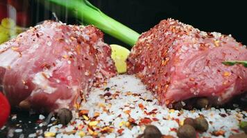 The chef cuts raw meat with a knife in slow motion. Raw beef steak sliced on a wooden board with spices and herbs. Delicious food concept video