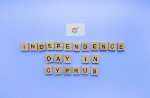 October 1, Independence Day in Cyprus, flag of Cyprus, minimalistic banner with the inscription in wooden letters on a blue background photo