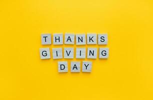 November 24, Thanksgiving Day, minimalistic banner with the inscription in wooden letters on an orange background photo