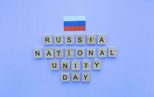 November 4, National Unity Day of Russia, the flag of Russia, a minimalistic banner with an inscription in wooden letters on a blue background photo