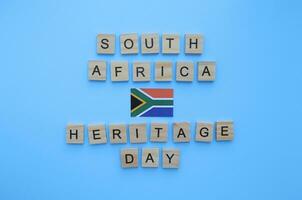 septiembre 24, patrimonio día en sur África, bandera de sur África, minimalista bandera con el inscripción en de madera letras en un azul antecedentes foto