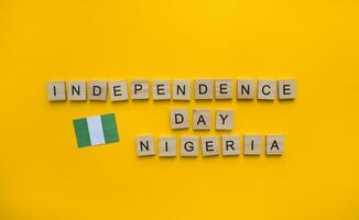 octubre 1, independencia día en Nigeria, el bandera de Nigeria, un minimalista bandera con un inscripción en de madera letras en un naranja antecedentes foto
