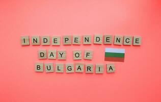 September 22, Independence Day of Bulgaria, flag of Bulgaria, minimalistic banner with the inscription in wooden letters on a red background photo