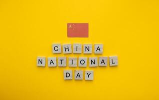 October 1, National Day in China, the flag of China, a minimalistic banner with an inscription in wooden letters on an orange background photo