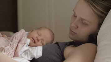 Mother and newborn daughter sleeping together in daytime video