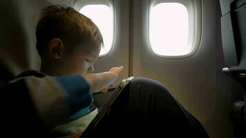 kleine jongen spelen op touchpad in het vliegtuig video