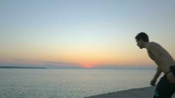 Man doing somersault while jumping into sea video