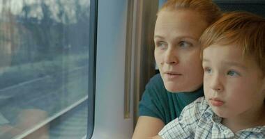 Mother and son looking out train window video