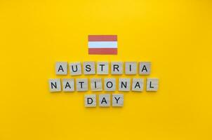 octubre 26, austriaco nacional día, bandera de Austria, minimalista bandera con de madera letras en un naranja antecedentes foto