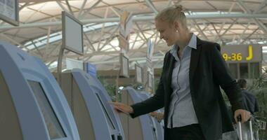 Frau mit selbst Check-In Maschine im das Flughafen video