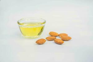 Almond oil with almond grains, white background photo