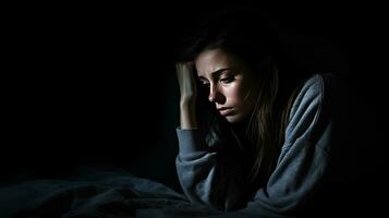 Depressed woman sitting head in hands on the bed in the dark bedroom, lonely and unhappy concept. Generative Ai photo