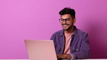 A happy Indian guy with laptop computer working or studying online on lilac background. Generative Ai photo