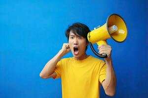 Wow face of Asian young man wears blue shirt hold scream in megaphone announces discounts sale Hurry up isolated on plain yellow background. Generative Ai photo