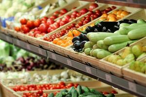 The grocery store sells various vegetables, tomatoes, cucumbers, eggplants, peppers, zucchini. photo