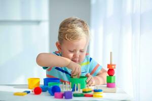 pequeño chico 2 años antiguo es jugado con un colores juguetes educativo lógica juguetes para niños. montessori juegos para niño desarrollo. foto