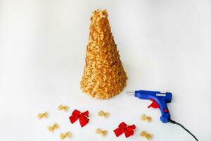 Christmas tree made of pasta, painted gold. Red bows for decorating the Christmas tree.  Handmade, DIY.  Step by step instructions for crafts for the new year. Step 3 . photo