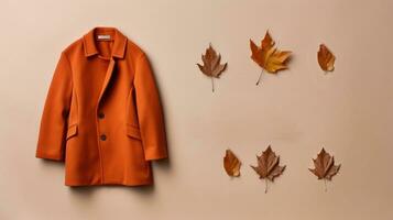 Coat and maple leaves on a beige background. Place for text. Generative AI photo