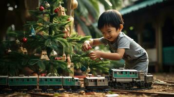 niño obras de teatro con juguete tren sentado ubder Navidad árbol foto