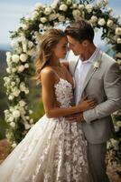 contento recién casados besos debajo un hermosa floral arco foto