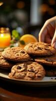 cerca arriba mujeres mano alcanza para chocolate galletas, equilibrio ellos con naranja jugo vertical móvil fondo de pantalla ai generado foto