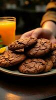 en detalle mano trabas chocolate galletas, hace malabares ellos con un naranja jugo vertical móvil fondo de pantalla ai generado foto