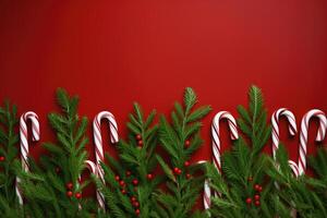 Navidad antecedentes con caramelo bastones y abeto ramas en rojo antecedentes. ai generado. foto