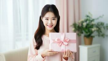 happy young asian woman holding pink gift box. AI Generated. photo