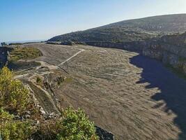 Natural monument of fossil dinosaur footprints in Serra D 'Aire in Pedreira do Galinha, in Portugal. A pedagogical circuit was created at the site, where visitors can see and touch the footprints photo