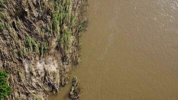 aéreo Visão do turvo Castanho floresta água fluindo dentro uma rio durante a chuvoso estação dentro norte tailândia. Visualizações do Chiang mai aldeias e a ping rio a partir de uma drone. video