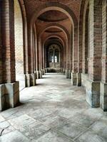 Old brick arch with tiles on the floor and closed doors. Elements of architectural decorations of buildings, arches and columns, door and window openings. On the streets in Catalonia, public places. photo