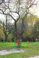 A bright playground surrounded by greenery, a tic-tac-toe game. Nice and cozy park for relaxation. photo