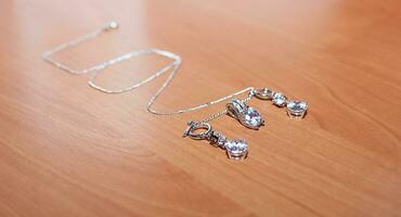 Jewelry and silver chain, on wooden desk. photo