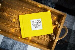 the yellow book lies on a wooden tray with the lights photo