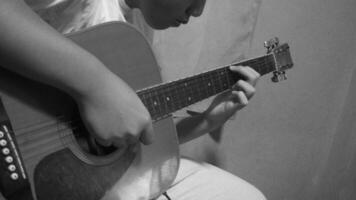 joven hombre jugando acústico guitarra. negro y blanco foto. cerca arriba. foto