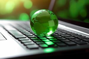 Green globe on a laptop keyboard with green bokeh background. photo