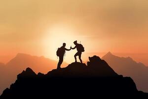 Silhouette of two men with backpacks on the top of the mountain. photo