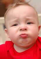 Closeup of unhappy caucasian boy in red t-shirt. photo