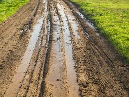 dirt road with dirt tracks in the countryside. photo