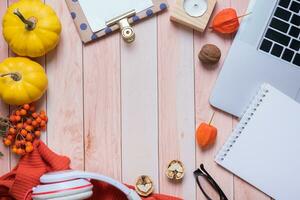 Composition with autumn decorations and a laptop on a wooden table flat lay, top view. Autumn desktop photo