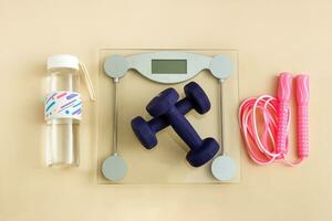 everything for training at home, floor scales with dumbbells, jump rope, water bottle photo