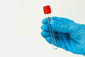 a hand in a medical glove holds an empty test tube on a light background with copy space photo