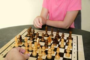 niño obras de teatro ajedrez con un adulto foto