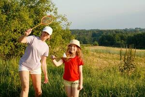 madre y hija jugar bádminton en un calentar verano noche foto