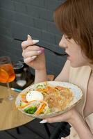 joven mujer con plato y tenedor disfrutando el gusto de quinua y salmón ensalada foto