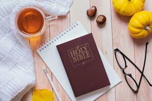 Santa Biblia y vista superior acogedora de otoño sobre fondo de madera. concepto de otoño de estudio bíblico foto