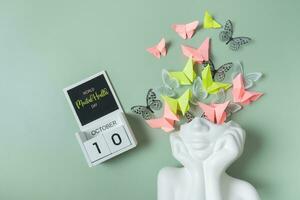 October 10 is World Mental Health Day. Head figurine with butterfly filling photo