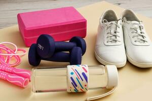 sneakers with dumbbells, jump rope, yoga brick and water bottle, sports activities photo