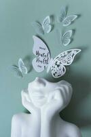 Plaster head with butterflies on a colored background. Mental health concept. World mental health day text photo